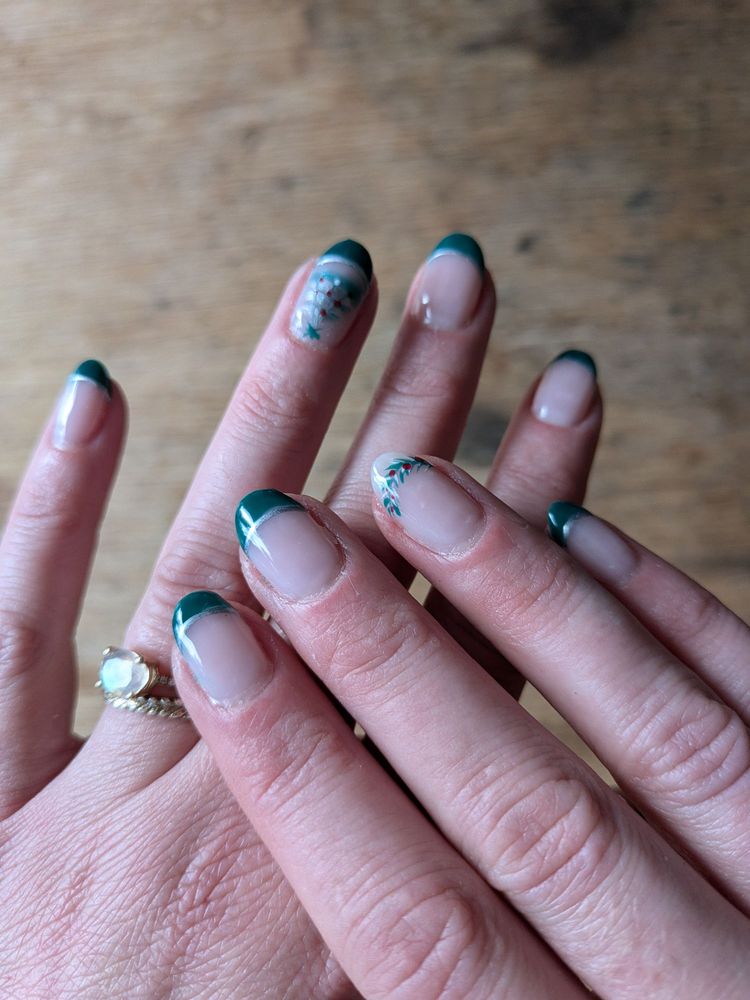 Deep green French manicure with delicate holiday nail art, done at T Nails & Spa in Greenwood, Seattle